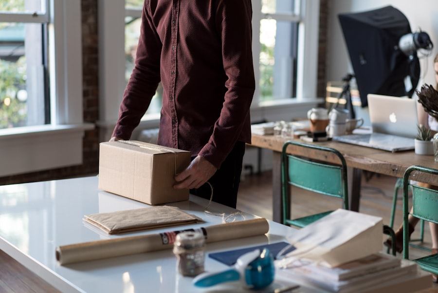 Team member packing office items into a carton at a workplace